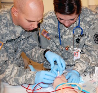 Army 1st Lt. Zachary Godwin, SAMMC clinical staff nurse, teaches Aissa how to place a peripheral intravenous catheter on a mannequin Oct. 11.
Photo by Chondra Perry