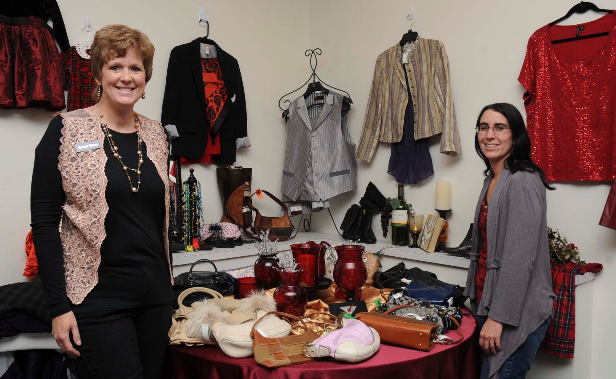 Brenda Eiman, B-One Yard Thrift and Consignment Store manager, and Valerie Hall, B-One Yard Thrift and Consignment store volunteer, display different clothes and items available at the B-One Yard Thrift store during the Thrift Store Volunteer Recognition Fashion Show at the Chapel Activities Center at Ellsworth Air Force Base, S.D., Oct. 18, 2012. The Ellsworth Officers’ and Civilians’ Spouses’ Club and Ellsworth Enlisted Spouses’ hosted the fashion show to showcase clothing items available at the store with proceeds going towards renovations inside the thrift store. (U.S. Air Force photo by Airman 1st Class Anania Tekurio/Released) 