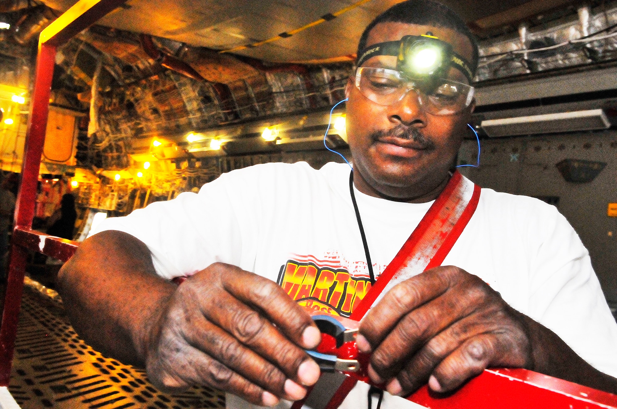 Raymond Tennyson, electronics mechanic, checks a clamp for running the electrical harness for the LAIRCM mod.(U. S. Air Force photo/Sue Sapp)