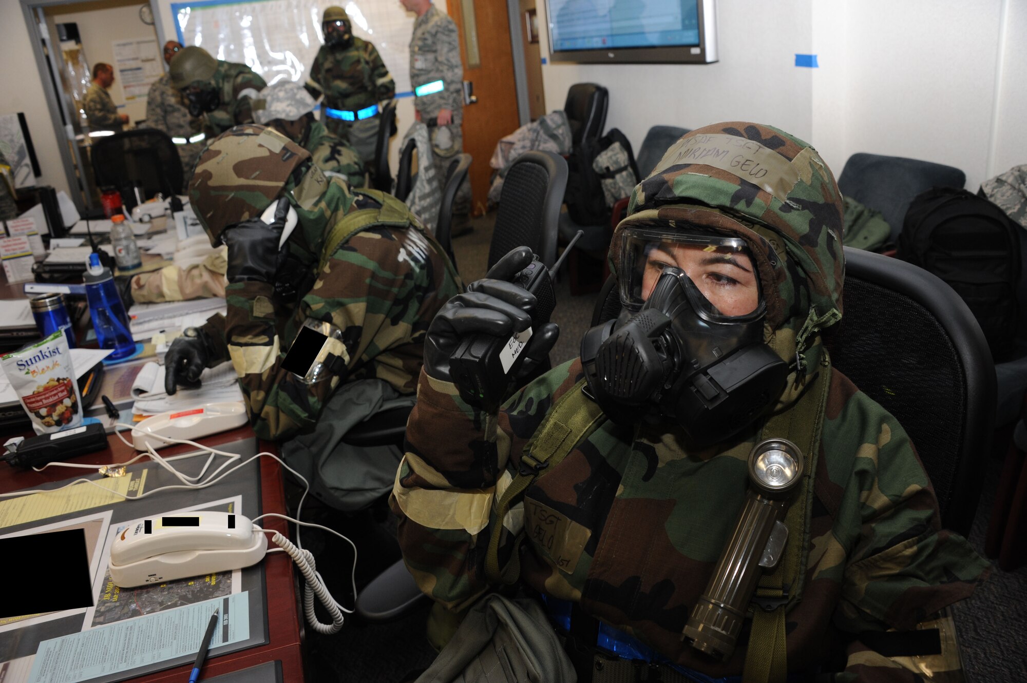 Tech. Sgt. Miriam Gelo, 514th Aeromedical Staging Squadron, speaks to members from the medical group in the Emergency Operations Center during the operational readiness exercise, Oct. 14 here. Members of the EOC worked to communicate with the entire base on a number of different exercise issues. This photo has been manipulated for security reasons. (U.S. Air Force photo by 2nd Lt. David J. Murphy/Released)
