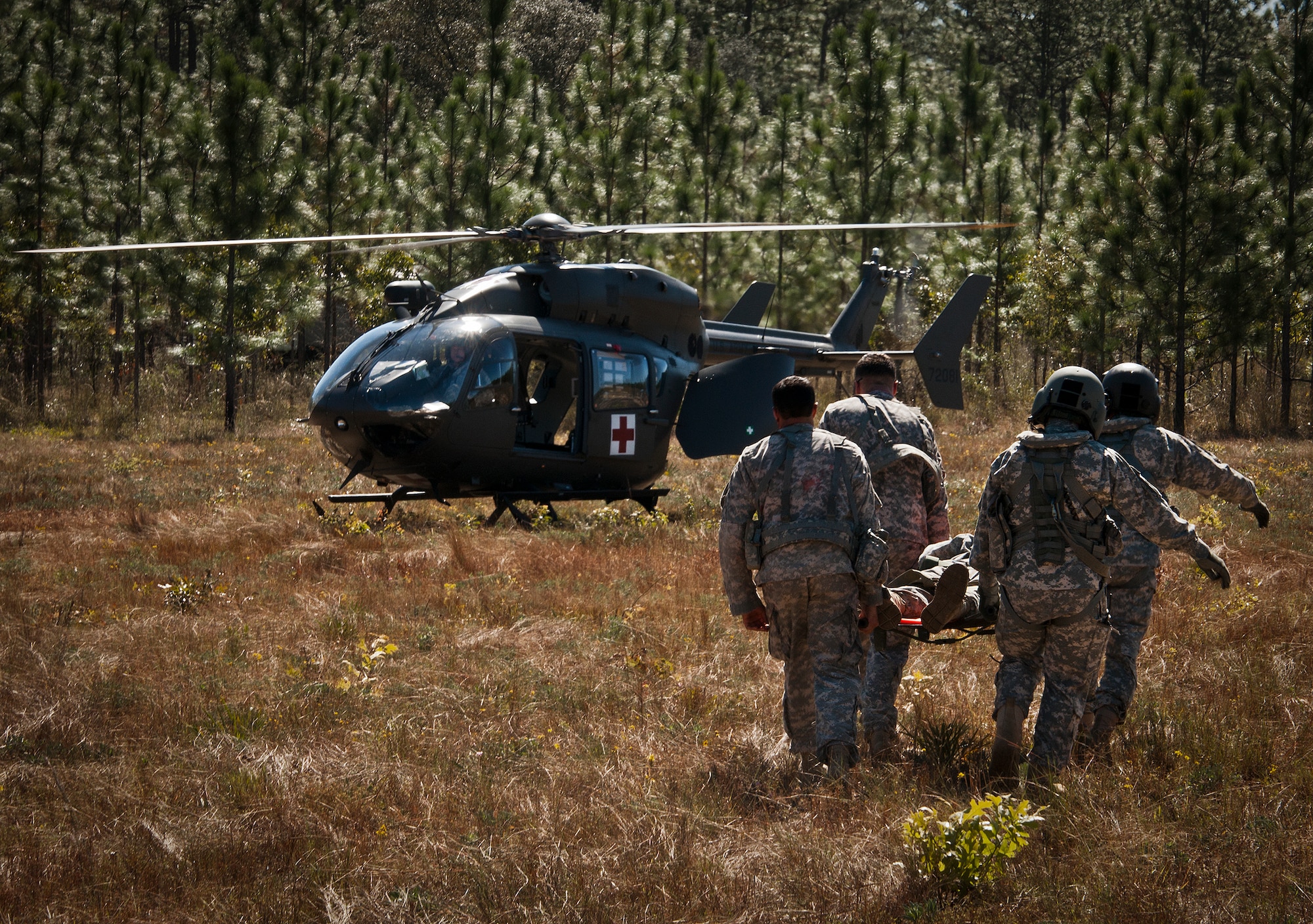 Soldiers carry a simulated victim to the helicopter for medical evacuation during a downed aircraft exercise on the Eglin range, Oct. 20.  The 6th Ranger Training Battalion, Team Eglin’s emergency responders and local medical facilities participated in the exercise that simulated a helicopter crash with 12 Soldiers injured deep within the Eglin range.  The victims were either evacuated by helicopter or by ambulance to area hospitals.  The annual exercise was to validate the battalion’s emergency procedures and test their communication with Team Eglin and local emergency and medical units.  (U.S. Air Force photo/Samuel King Jr.)