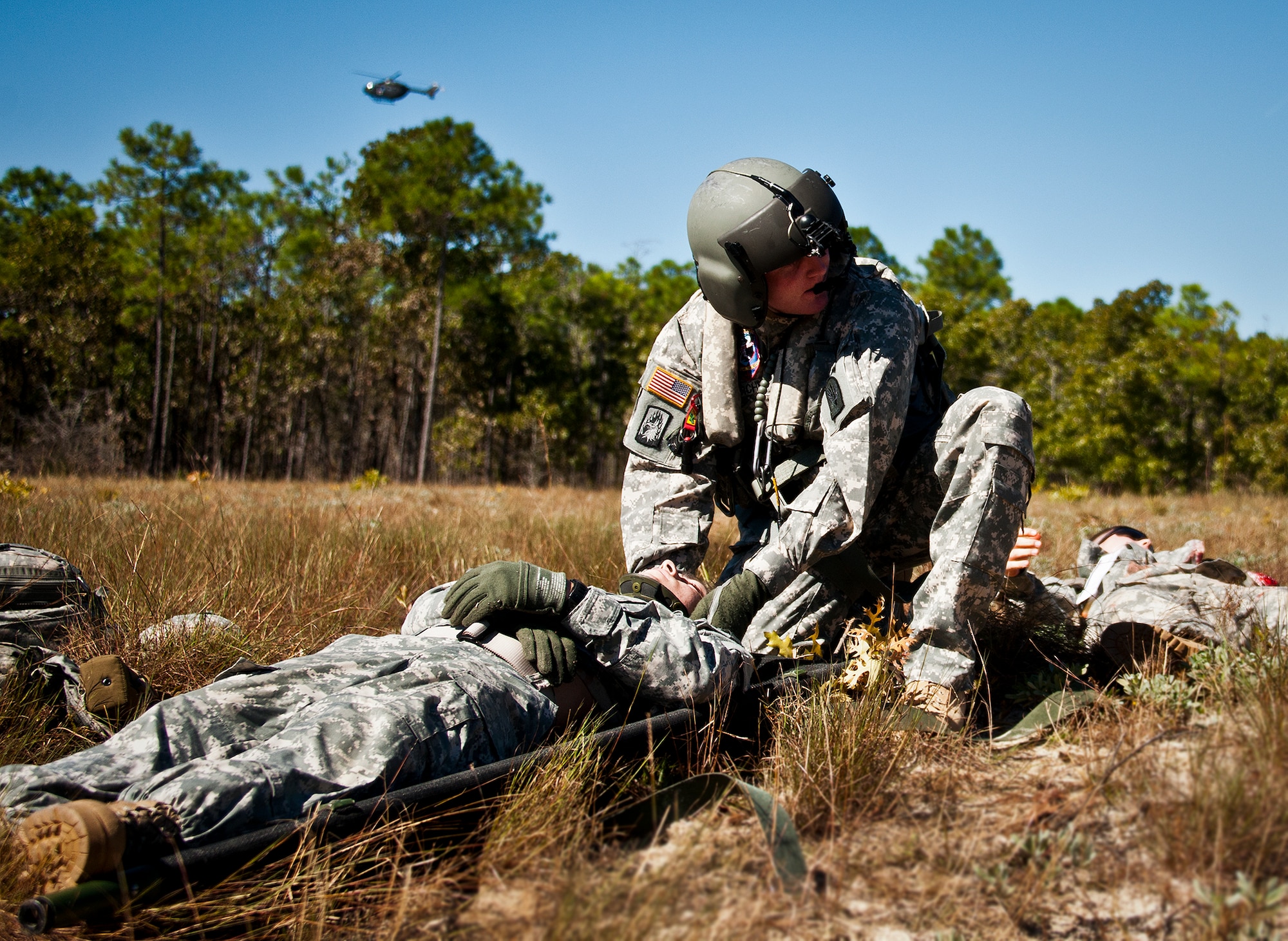 An Army medic secures a simulated victim’s head as a medical evacuation helicopter circles during an exercise on the Eglin range, Oct. 20.  The 6th Ranger Training Battalion, Team Eglin’s emergency responders and local medical facilities participated in the exercise that simulated a helicopter crash with 12 Soldiers injured deep within the Eglin range.  The victims were either evacuated by helicopter or by ambulance to area hospitals.  The annual exercise was to validate the battalion’s emergency procedures and test their communication with Team Eglin and local emergency and medical units.  (U.S. Air Force photo/Samuel King Jr.)