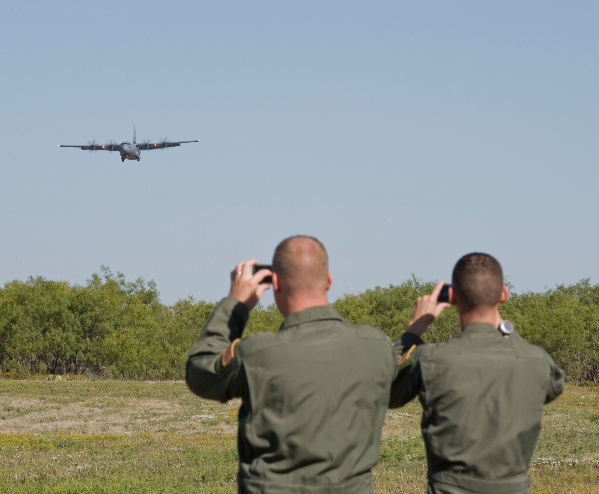 Airmen from the 317th Airlift Group watch a C-130J come in for a landing during Impact Day, Oct. 19, 2012, at Dyess Air Force Base, Texas. Maintainers from the 317th Airlift Group learned the outcome of generating an aircraft when it flies and resupplies a drop zone. (U.S. Air Force photo by Airman 1st Class Jonathan Stefanko/ Released)