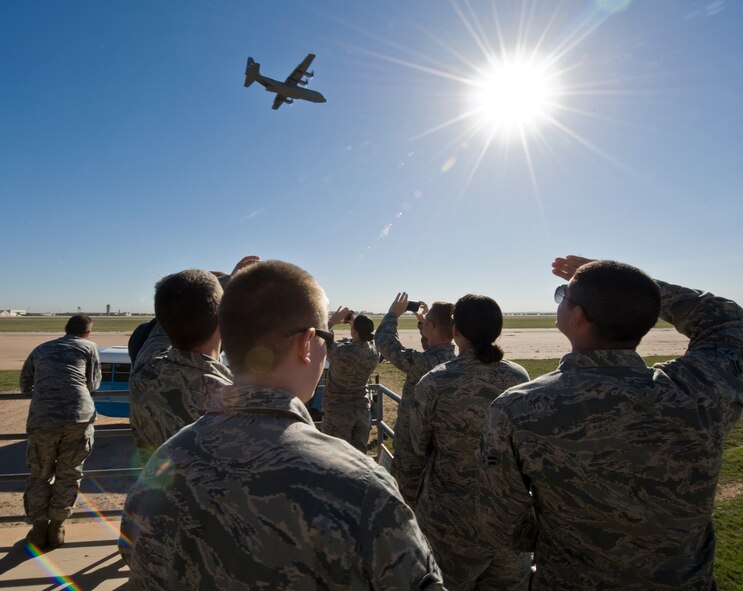 Airmen from the 317th Airlift Group watch a C-130J flyover during Impact Day Oct. 19, 2012, at Dyess Air Force Base, Texas. Maintainers from the 317th Airlift Group learned the outcome of generating an aircraft when it flies and resupplies a drop zone. (U.S. Air Force photo by Airman 1st Class Jonathan Stefanko/ Released)