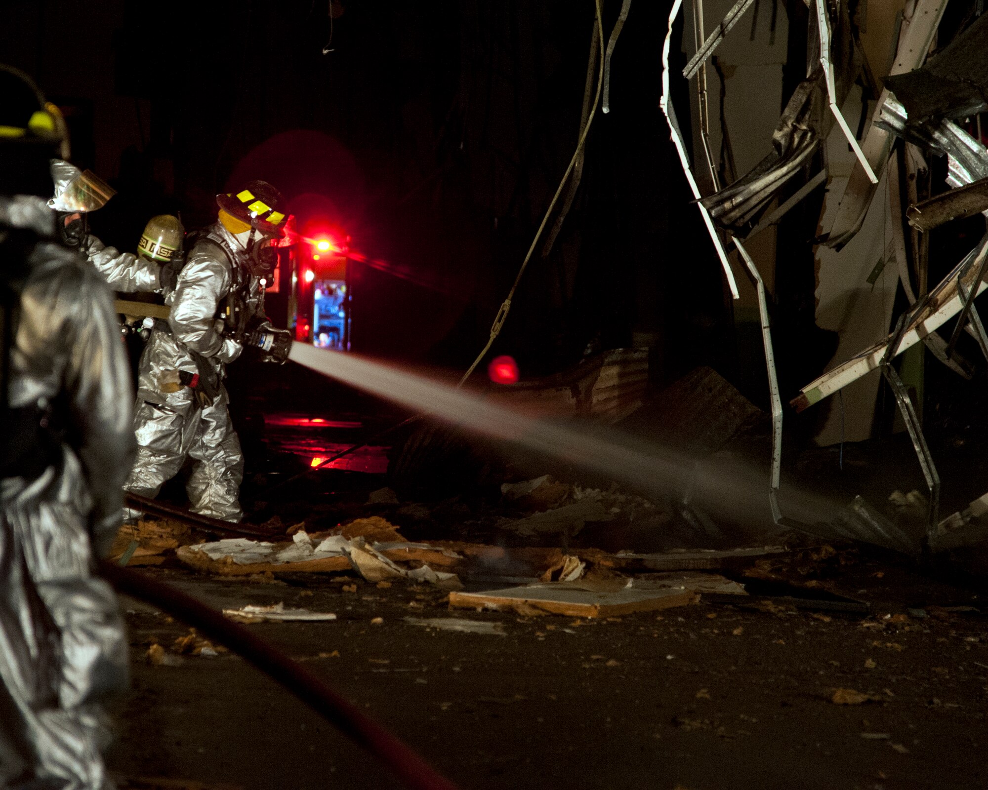 ALTUS AIR FORCE BASE, Okla. -- A firefighter from the 97th Civil Engineer Squadron fire department sprays water on the embers of a fire at a vacant building on base Oct. 24, 2012. The cause of the fire is unknown at this time and occurred in an unoccupied building that was in the process of being demolished. (U.S.  Air Force photo by Senior Airman Kenneth W. Norman / Released)