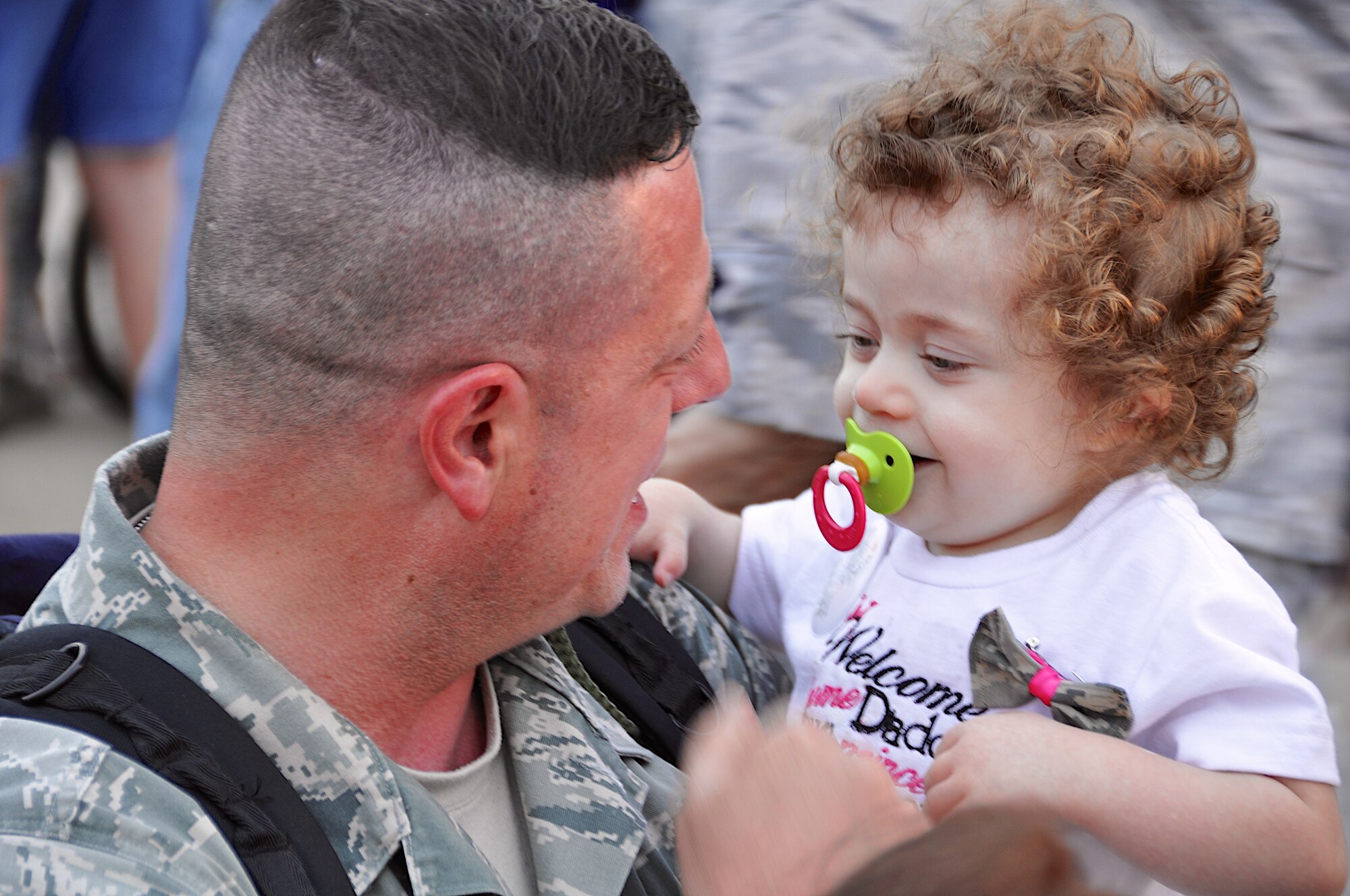 Staff Sgt. Barry Tate, 610th Security Forces Squadron, greets his daughter for the first time in more than six months. More than 50 deployed members from the 301st Security Forces Squadron and 610th Security Forces Squadron, stationed at Naval Air Station Fort Worth Joint Reserve Base, Texas, returned Oct. 25, 2012. The members were deployed to Saudi Arabia for six months in support of Operation Enduring Freedom. A large group of 301st Fighter Wing family and friends gathered to welcome our returning Airmen home.