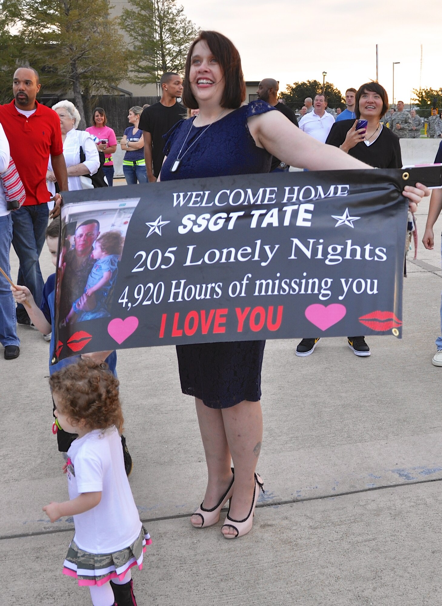 Waiting for the plane, Staff Sgt. Barry Tate's wife displays how much he's been missed with a banner of love. More than 50 deployed members from the 301st Security Forces Squadron and 610th Security Forces Squadron, stationed at Naval Air Station Fort Worth Joint Reserve Base, Texas, returned Oct. 25, 2012. The members were deployed to Saudi Arabia for six months in support of Operation Enduring Freedom. A large group of 301st Fighter Wing family and friends gathered to welcome our returning Airmen home.