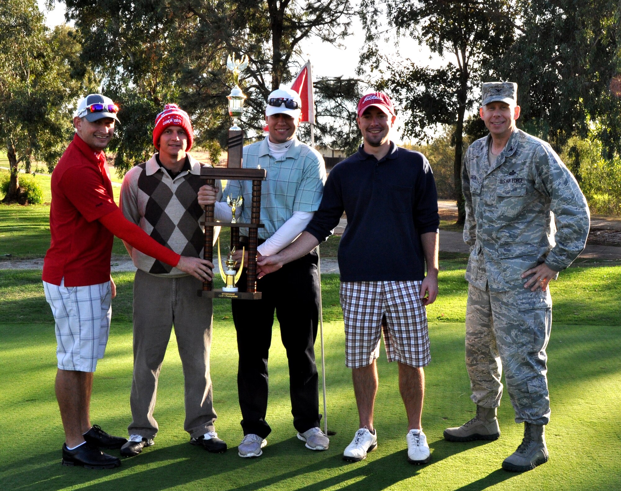 Col. Jason Green, 9th Mission Support Group commander, present members of 13th Intelligence Squadron the Intramural Golf Championship trophy at Coyote Run Golf Course Beale Air Force Base, Calif., Oct. 23, 2012. The 13th IS defeated the 9th Force Support Squadron at 18 holes of match-play golf. (U.S. Air Force photo by Staff Sgt. Robert M. Trujillo/Released)