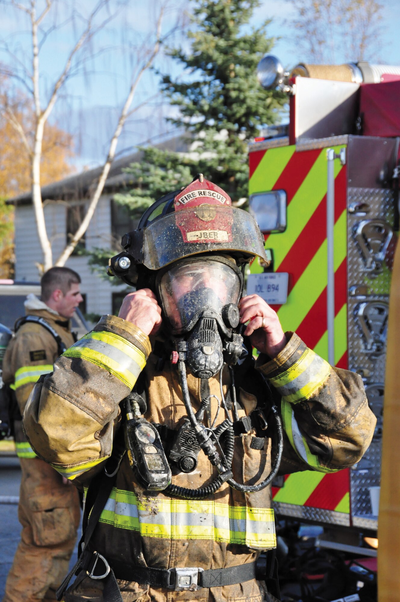 JBER firefighter Airman 1st Class Andrew Morris removes his respirator after battling a fire Sept. 28, 2011. (U.S. Air Force photo/Maj. Joseph Coslett)