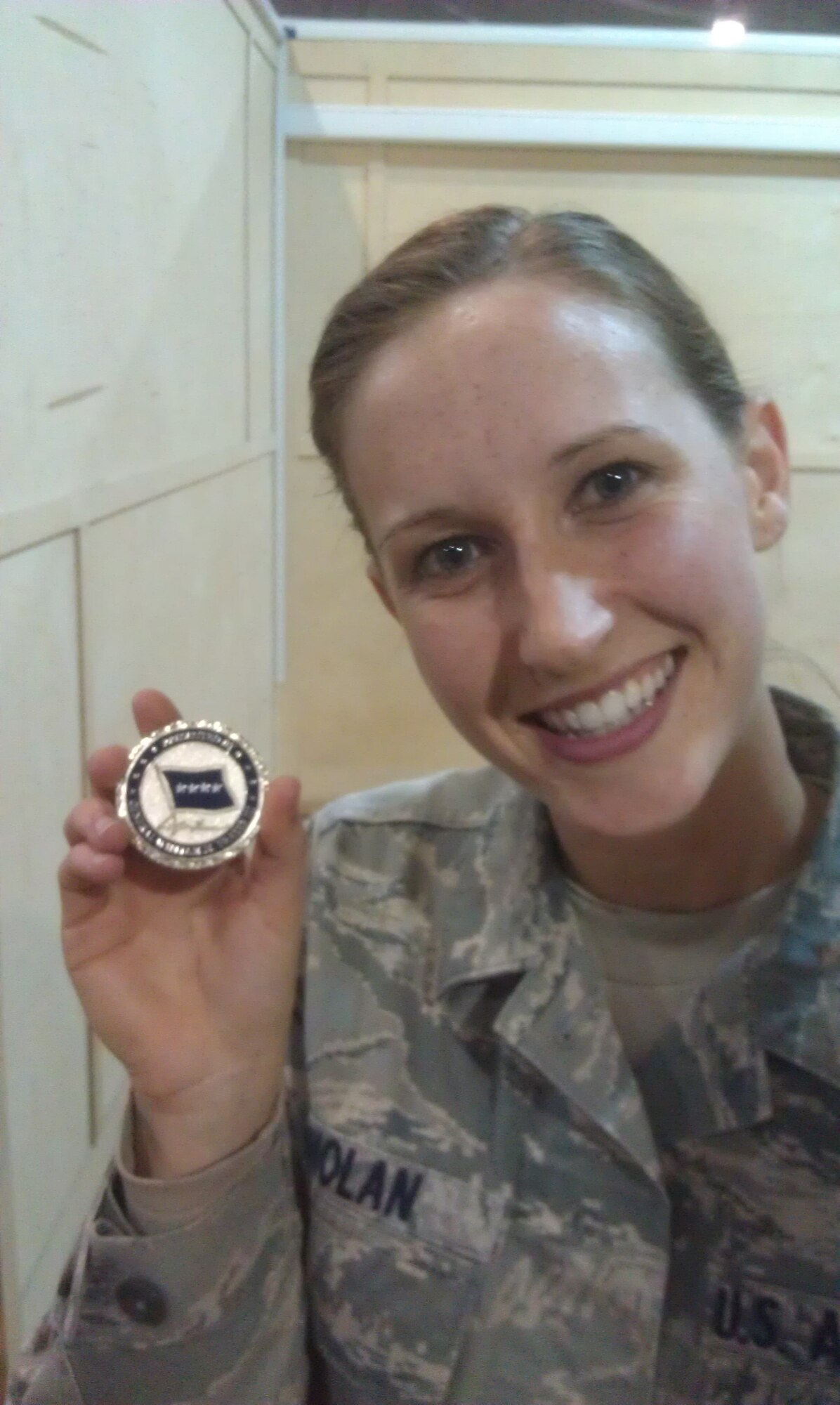 Senior Airman Ashley Nolan, an aerial port specialist from the 512th Airlift Wing, Dover Air Force Base, Del., shows off a commander's coin she received from Gen. William M. Fraser III, U.S. Transportation Command commander,during his visit to the Transit Center at Manas, Kyrgyz Republic, Oct. 23, 2012. Nolan, who's deployed to the 376th Expeditionary Logistics Readiness Squadron, served on the briefing team for his tour. (U.S. Air Force photo/SenMaster Sgt. Ed Hendershot)