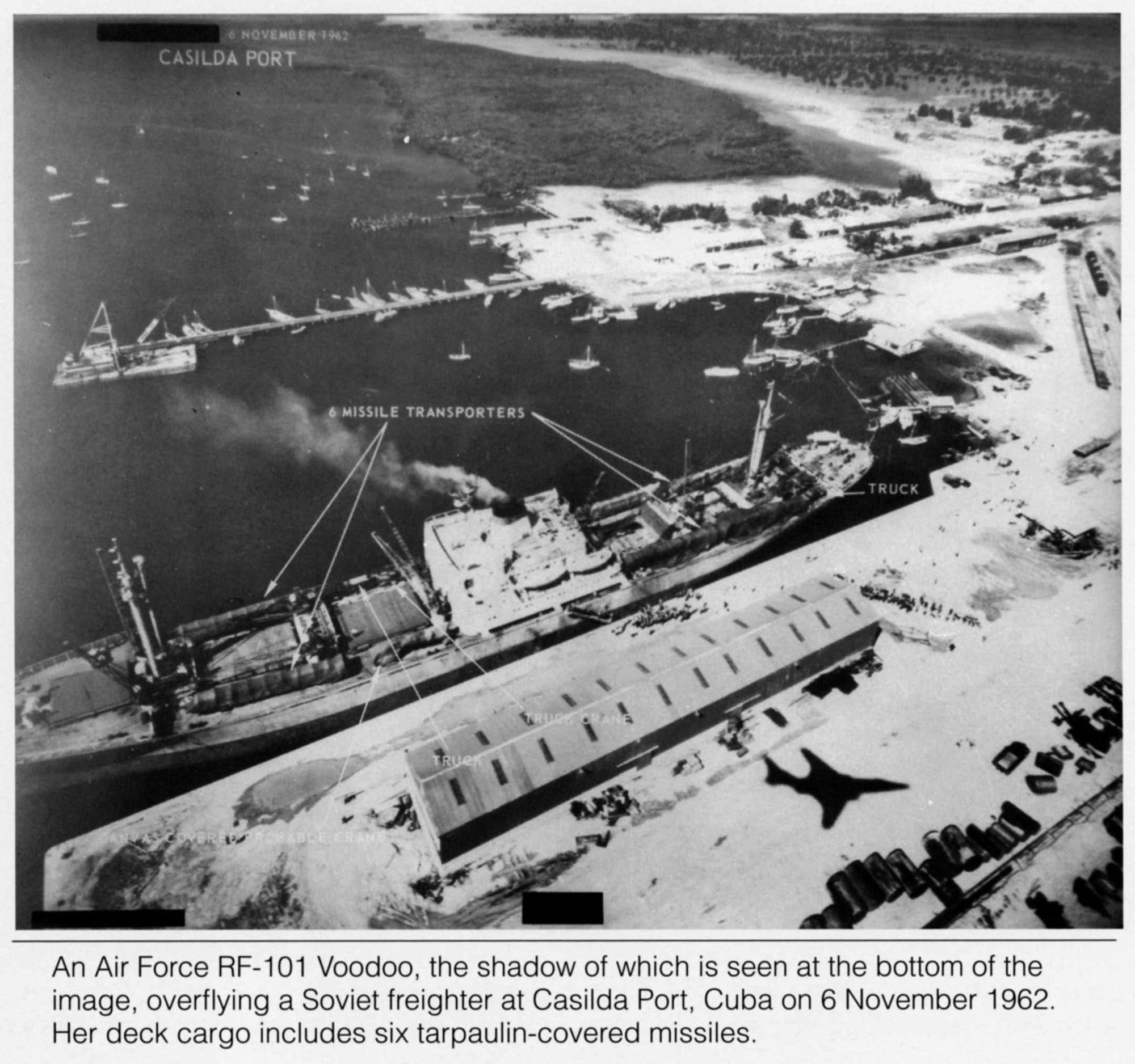 An Air Force RF-101 Voodoo, its shadow seen on the lower right, flies above a Soviet freighter at Casilda Port, Cuba on Nov. 6, 1962. The ship's deck cargo includes six tarpaulin-covered missiles. (Coutesy photo)