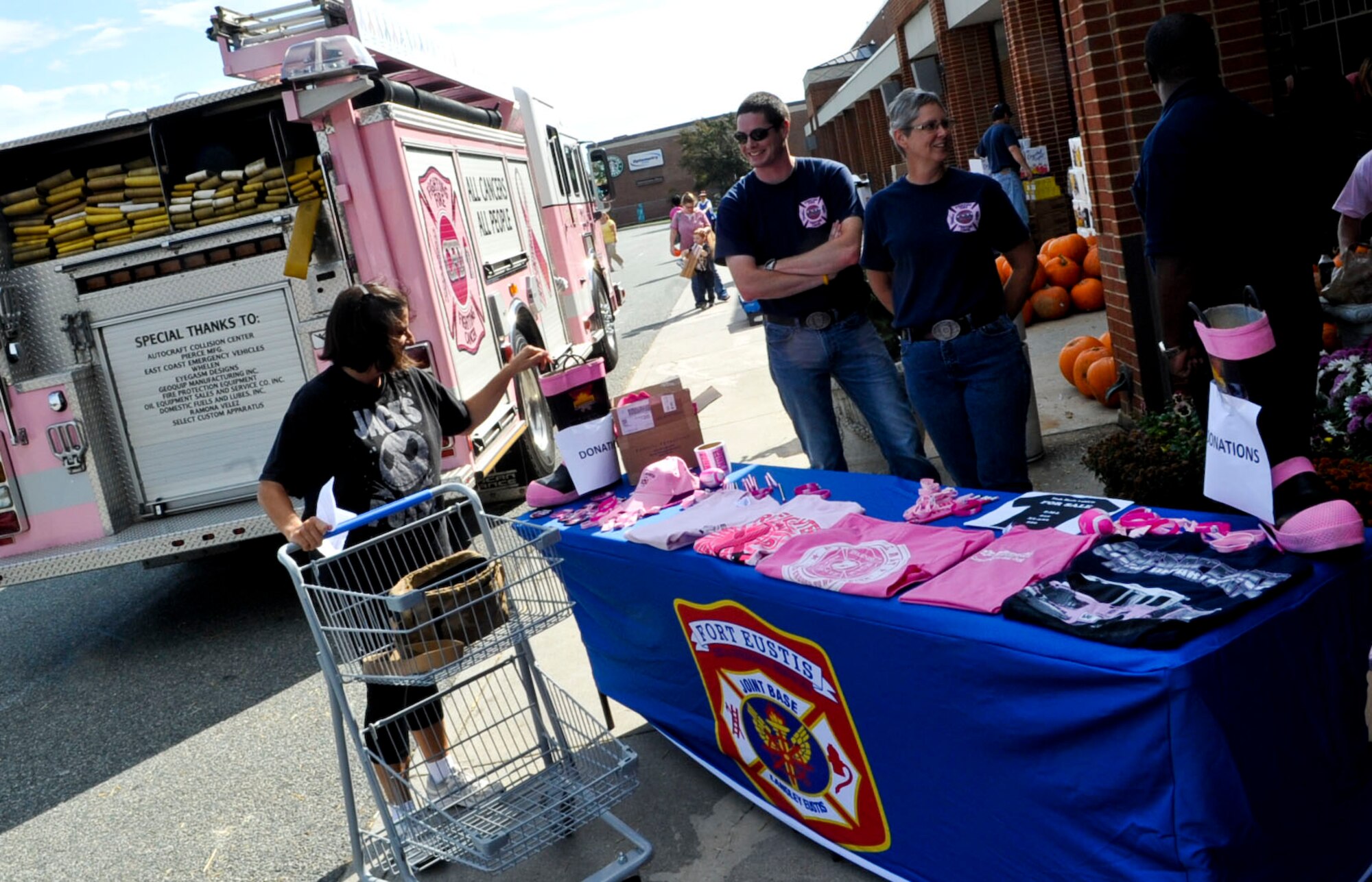Members of the Chesapeake, Va., and Fort Eustis fire departments man a table full of free goodies and t-shirts for sale along with the Chesapeake pink fire truck and ambulance outside the Fort Eustis commissary, Oct. 24, 2012. The truck and table were setup to provide awareness and literature about breast cancer. (U.S. Air Force photo by Staff Sgt.  Wesley Farnsworth / Released)