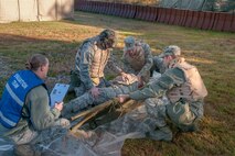 HANSCOM AIR FORCE BASE, Mass. - Capt. Elizabeth Norris, 66th Medical Squadron nurse, evaluates Airmen as they perform a litter carry as part of a Self Aid and Buddy Care scenario that took place during the base readiness exercise Oct. 18. The BRE tested deployment readiness through simulated ground and chemical attacks. (U.S. Air Force photo by Rick Berry)