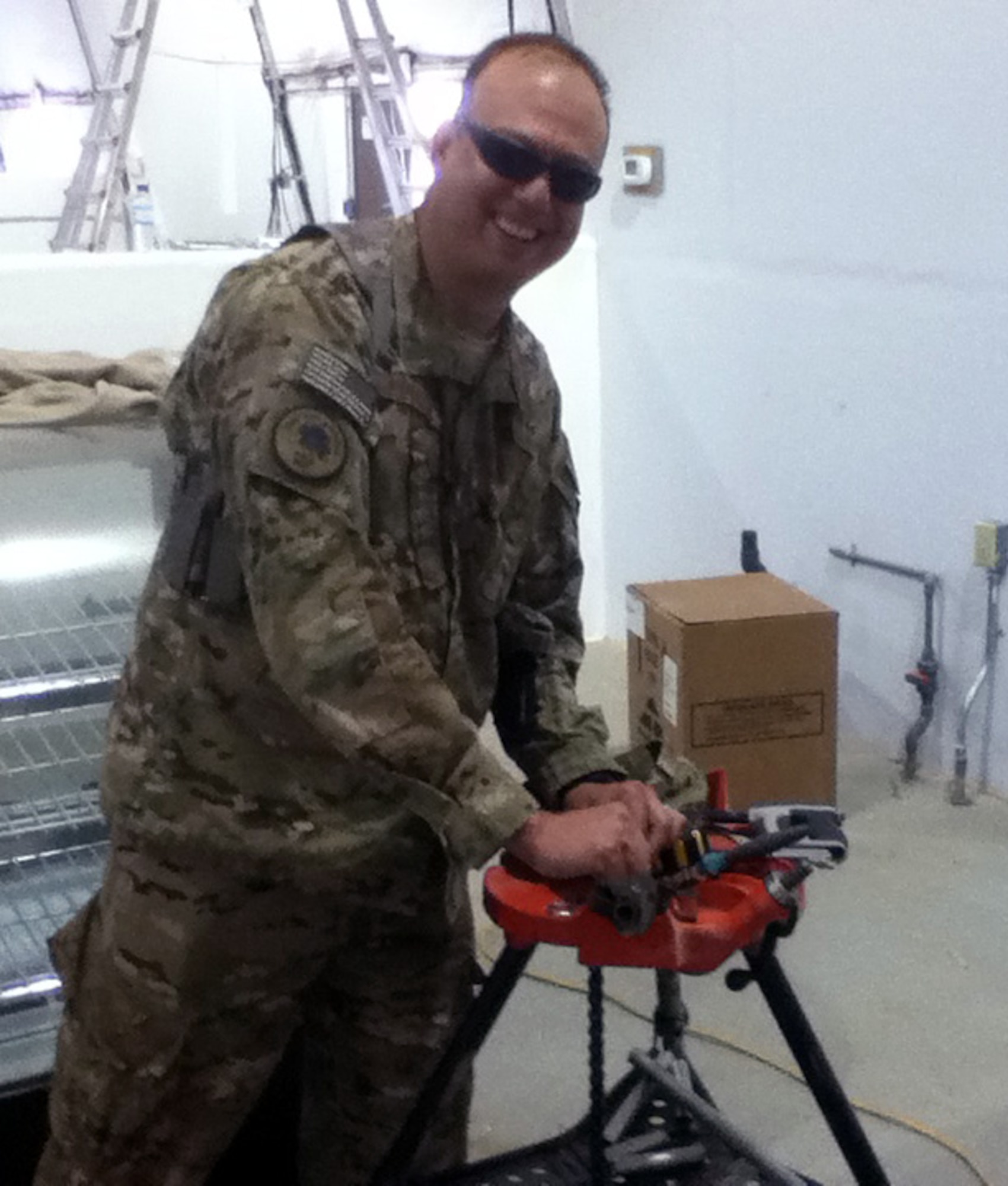 SHINDAND AFGHANISTAN -- Maj. Joel Purcell helps his troops cut conduit to repair electrics in a 23,000 square-foot dining facility. During his deployment, Purcell was charge of a detachment that designed, managed, constructed, and maintained facilities and infrastructure allowing combat forces to continue their mission. This was his fourth deployment. (Courtesy photo)