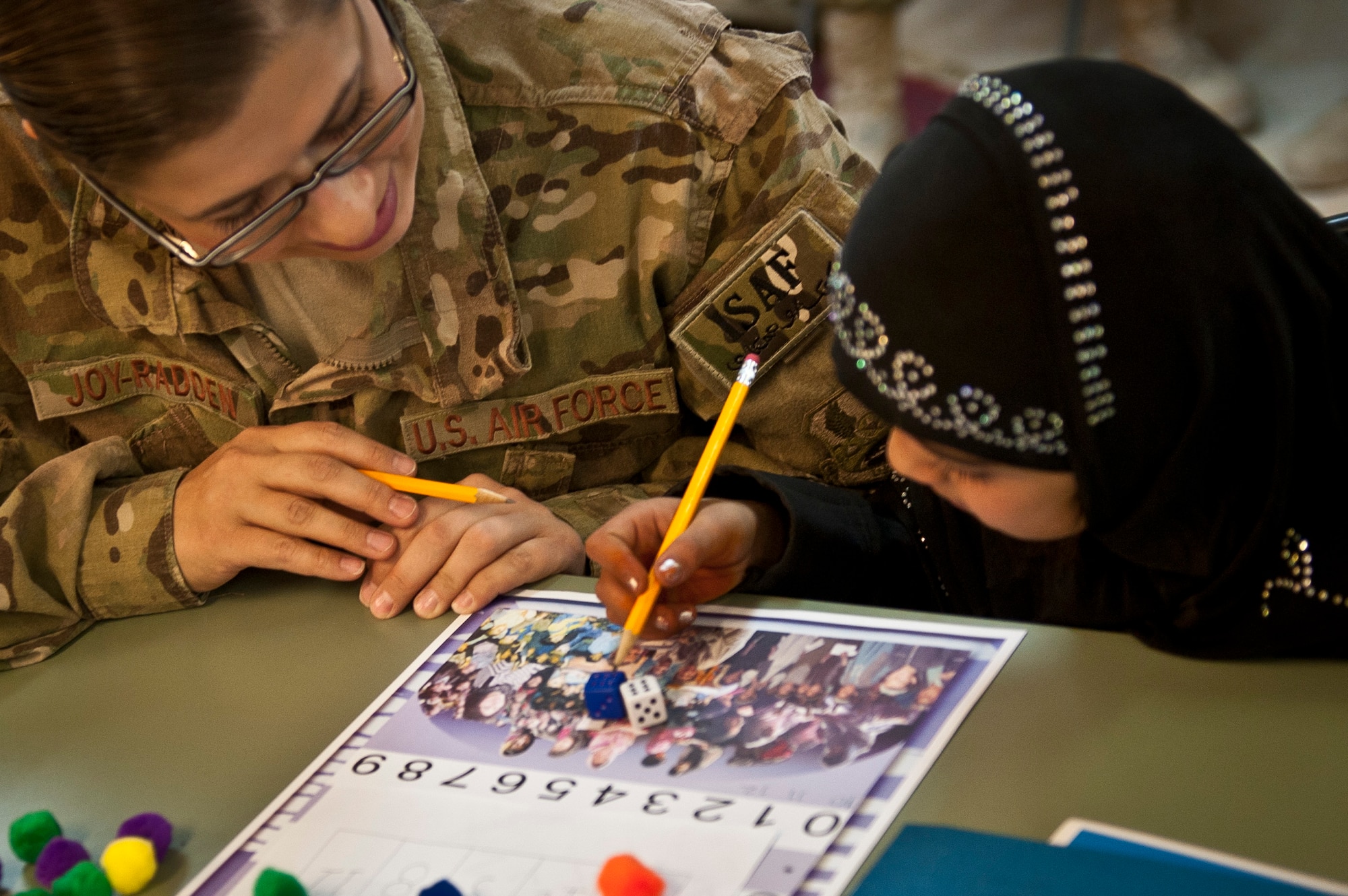 Yagana, a local Afghan student, and Capt. Angela Joy-Radden, a volunteer from the 455th Expeditionary Operations Support Squadron, play a counting game together during a “Cat in the Hat” education session at Bagram Airfield, Afghanistan, Oct. 14, 2012. Bagram volunteers come out every week to mentor and educate local youth. (U.S. Air Force photo/Capt. Raymond Geoffroy)