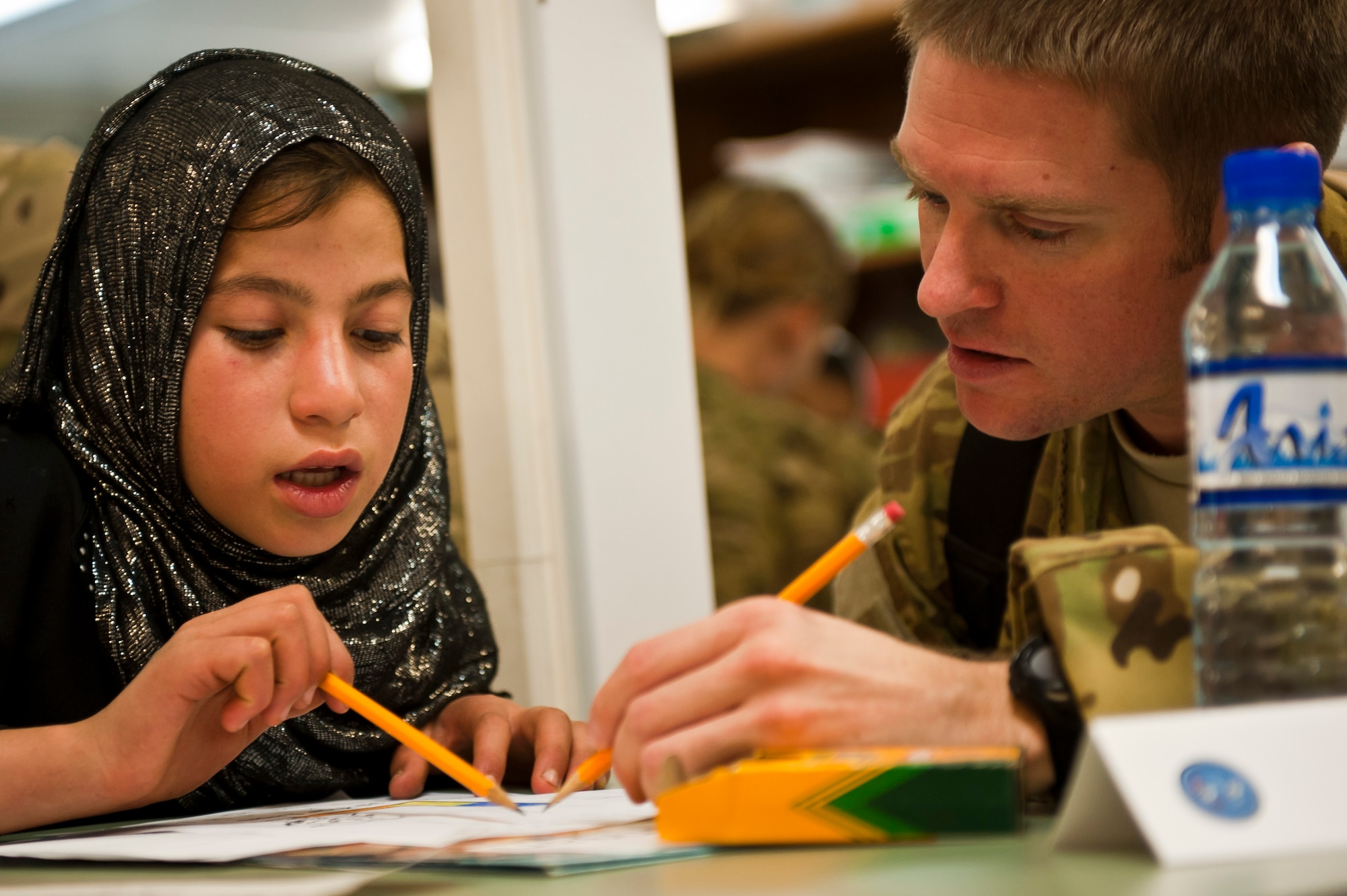 Muzghan, a local Afghan student, and Capt. Leonard Spigiel, a volunteer from the 774th Expeditionary Airlift Squadron, work on a project together during a “Cat in the Hat” education session at Bagram Airfield, Afghanistan, Oct. 14, 2012. The educational outreach program supports the International Security Assistance Force’s counter-insurgency efforts by enabling positive interaction between U.S. service members and the local community. (U.S. Air Force photo/Capt. Raymond Geoffroy)