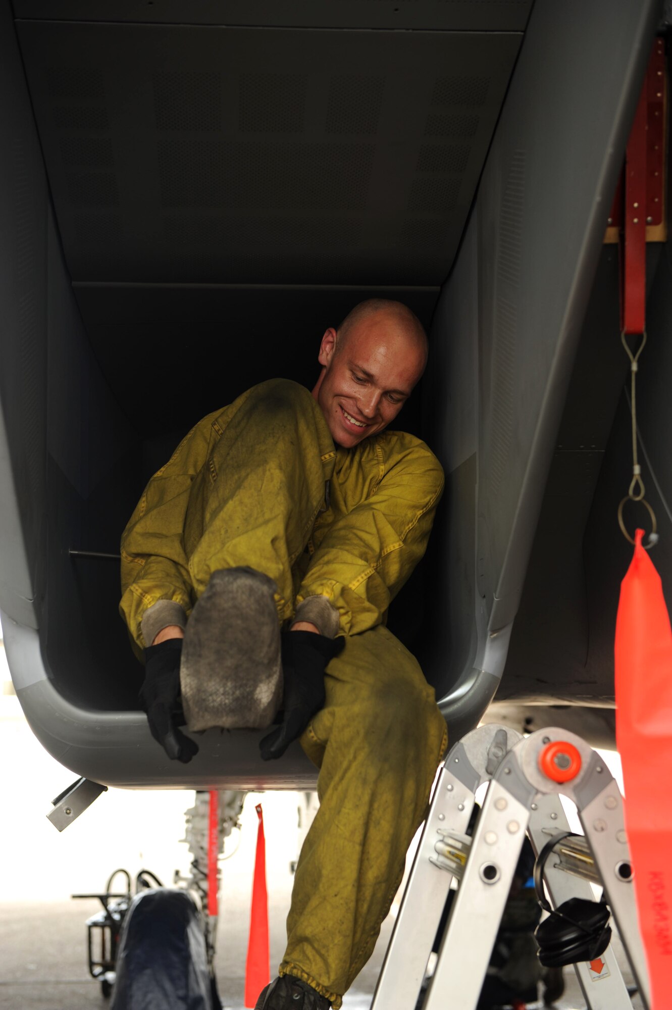 U.S. Air Force Staff Sgt. William Telschow, 67th Aircraft Maintenance Unit crew chief, places cloth covers over his boots to keep exhaust residue from accumulating on them during Exercise Beverly Bearcat 12-1, an operational readiness inspection on Kadena Air Base, Japan, Oct. 24, 2012. The readiness inspection tests the 18th Wing on its ability to survive and operate during a contingency. (U.S. Air Force photo/Airman 1st Class Hailey R. Davis)