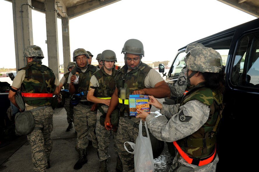 U.S. Staff Sgt. Christina Haga, 18th Wing chaplain assistant, hands out snacks to Airmen with the 18th Aircraft Maintenance Squadron during Exercise Beverly Bearcat 12-1, an operational readiness inspection on Kadena Air Base, Japan, Oct. 24, 2012. Haga assisted Chaplain (Capt.) Kennie Neal with a morale-boosting visitation to the 18th AMXS and 18th Munitions Squadron. (U.S. Air Force photo/Airman 1st Class Hailey R. Davis)
