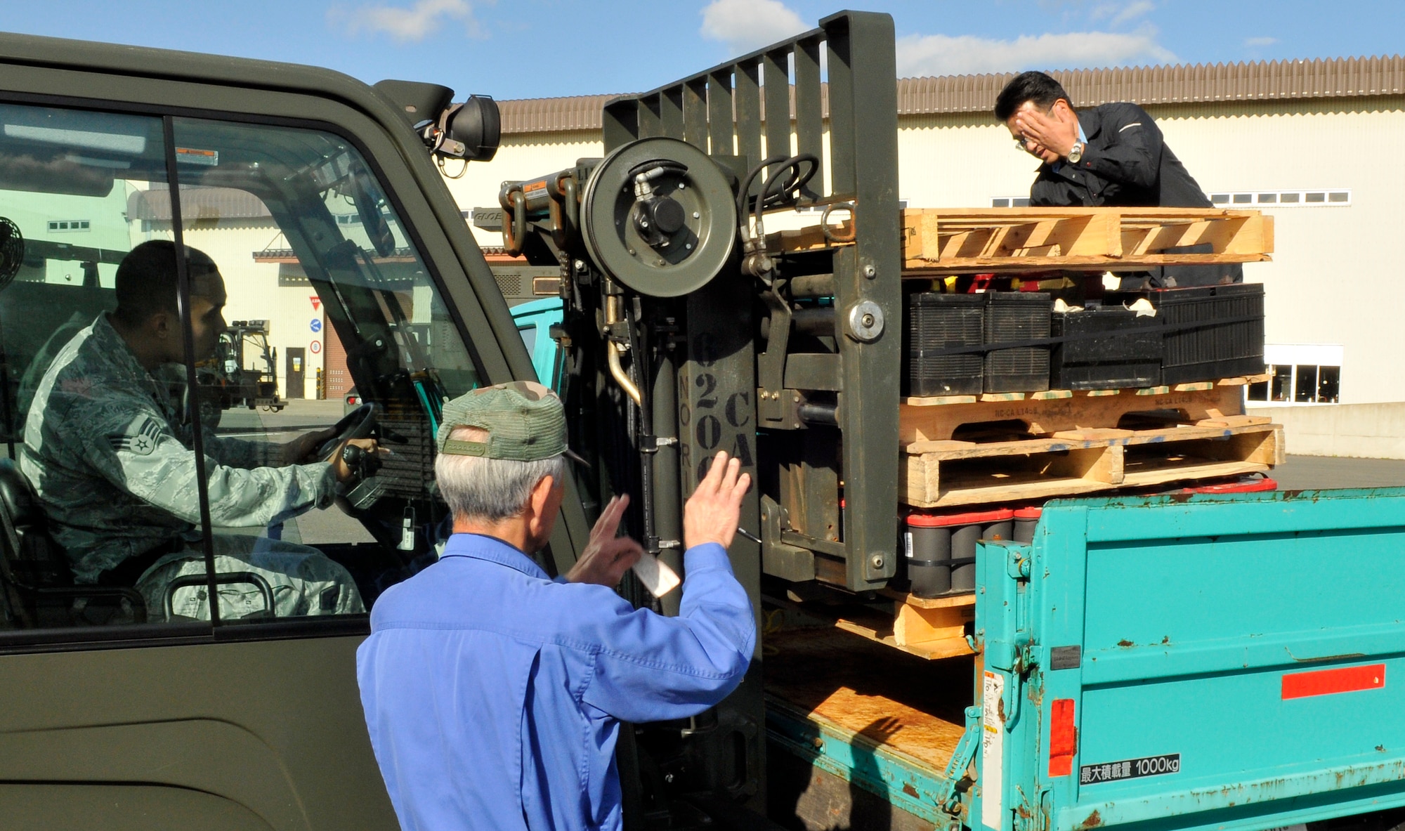 U.S. Air Force Senior Airman Bryan Alvarado, 35th Logistics Readiness Squadron vehicle maintenance support section technician, uses a forklift to lift a pallet of lead acid batteries into a truck as a Japanese resident, front, and Koji Takayama, Hazardous Waste Storage Area site manager, right, guide him in at Misawa Air Base, Japan, Oct. 24, 2012. Collection point custodians call the hazardous waste storage area for pick up when their collection point gets full; unless the custodian has a way to bring the waste to the facility. (U.S. Air Force photo by Tech. Sgt. Phillip Butterfield) 

