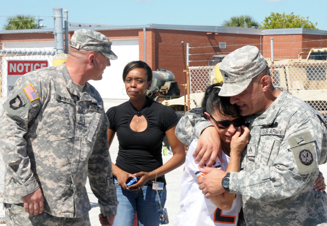 Army Sgt. 1st Class Robert M. Swanson, left, looks back at his wife, Eliana, after saying goodbye as Army Staff Sgt. Michael A. Martinez hugs his own wife before a final farewell formation at Max R. Stover Army Reserve Center in St. Petersburg, Fla., Oct. 22, 2012. 