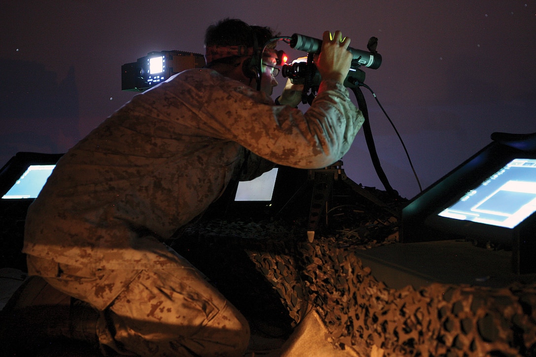 Cpl. David B. Schmidt locates his target through the sights on a laser range finder while simulating calls for fire during a night operation test on the supporting arms virtual trainer at Camp Hansen Oct. 16. Marines learned how to properly control aerial, naval and artillery fires during a joint fire observer course Oct. 5-19. Schmidt is a reconnaissance man with 3rd Reconnaissance Battalion, 3rd Marine Division, III Marine Expeditionary Force. 