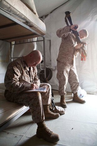 U.S. Marine Corps Gunnery Sgt. Joseph A. Stager, left, and Cpl. Grant N. Yoder, right, both with Headquarters Company, Regimental Combat Team 7 (RCT-7) inventory weapons and gear at Manas Air Base, Chuy province, Kyrgyzstan, Oct. 13, 2012. RCT-7 is staged a few days on Manas Air Base before continuing on to their final destination in Afghanistan for a yearlong deployment. (U.S. Marine Corps photo by Cpl. Alejandro Pena/Released)