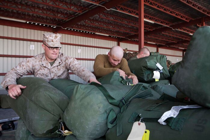 U.S. Marine Corps Lance Cpls. Randle J. McCain, left, and Nicholas Patterson, right, both with Headquarters Company, Regimental Combat Team 7 (RCT-7), load gear onto palletes prior to proceeding to Afghanistan at Manas Air Base, Chuy province, Kyrgyzstan, Oct. 13, 2012. RCT-7 staged a few days on Manas Air Base before continuing on to their final destination in Afghanistan for a yearlong deployment. (U.S. Marine Corps photo by Cpl. Alejandro Pena/Released)