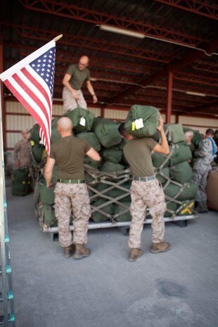 U.S. Marines with Headquarters Company, Regimental Combat Team 7 (RCT-7) load gear onto pallets prior to proceeding to Afghanistan at Manas Air Base, Chuy province, Kyrgyzstan, Oct. 13, 2012. RCT-7 staged a few days on Manas Air Base before continuing on to their final destination in Afghanistan for a yearlong deployment. (U.S. Marine Corps photo by Cpl. Alejandro Pena/Released)