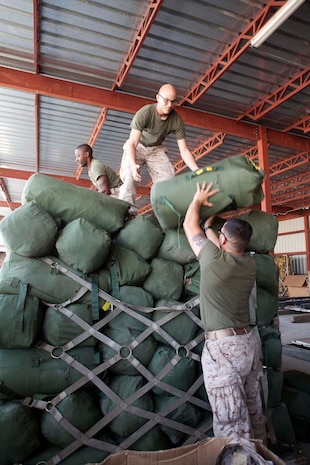 U.S. Marines with Headquarters Company, Regimental Combat Team 7 (RCT-7), load gear onto pallets prior to proceeding to Afghanistan at Manas Air Base, Chuy province, Kyrgyzstan, Oct. 13, 2012. RCT-7 staged a few days on Manas Air Base before continuing on to their final destination in Afghanistan for a yearlong deployment. (U.S. Marine Corps photo by Cpl. Alejandro Pena/Released)