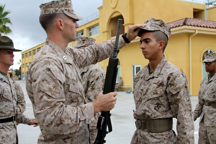 Capt. Roger Hollenbeck, series commander, Company F, 2nd Recruit Training Battalion, inspects the cover of Recruit Jorge Lugo, Platoon 2133, Oct. 22 aboard Marine Corps Recruit Depot San Diego. The series commander inspection is the second inspection recruits go through during recruit training. These inspections test a recruit's bearing and ability to carry out a small tasks, such as a rifle movement, to display their confidence.
