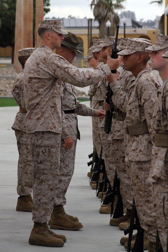 Capt. Roger Hollenbeck, series commander, Company F, 2nd Recruit Training Battalion, hands back a recruit's rifle to finish the drill movement "inspection arms" Oct. 22 aboard Marine Corps Recruit Depot San Diego. The series commander inspection is the second inspection recruits go through during recruit training. These inspections test a recruit's bearing and ability to carry out a small tasks, such as a rifle movement, to display their confidence.