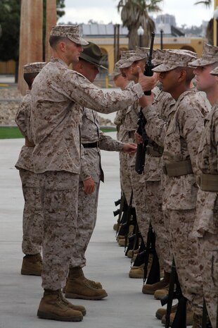 Capt. Roger Hollenbeck, series commander, Company F, 2nd Recruit Training Battalion, hands back a recruit's rifle to finish the drill movement "inspection arms" Oct. 22 aboard Marine Corps Recruit Depot San Diego. The series commander inspection is the second inspection recruits go through during recruit training. These inspections test a recruit's bearing and ability to carry out a small tasks, such as a rifle movement, to display their confidence.