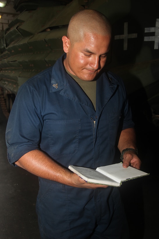 Corporal Harold E. Campo, amphibious assault vehicle mechanic, AAV Platoon, India Company, Battalion Landing Team 3/5, 15th Marine Expeditionary Unit, checks his logbook to see what needs to be done on the AAVs in the well deck of the USS Green Bay, Oct. 17. In order to bring the Marines of India Co. to shore, the company’s AAV Platoon puts in countless hours toward achieving readiness with their AAVs. India Co. is one of three rifle companies that make up BLT 3/5, the 15th MEU’s ground combat element. The 15th MEU is currently embarked as part of the Peleliu Amphibious Ready Group, while they serve as the nation's rapid-response sea-based Marine Air Ground Task Force for Western Pacific Deployment 12-02.  Campo, 25, is from Ridgefield, N.J.
