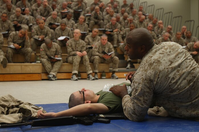 Staff Sgt. Van Black, academic instructor, Instructional Training Company, Support Battalion, shows recurits of Company D, 1st Recruit Training Battalion, how to treat a sunken chest wound aboard Marine Corps Recruit Depot San Diego, Oct. 23. During his demonstration Black discussed the moves he made and answered all questions from recruits. 