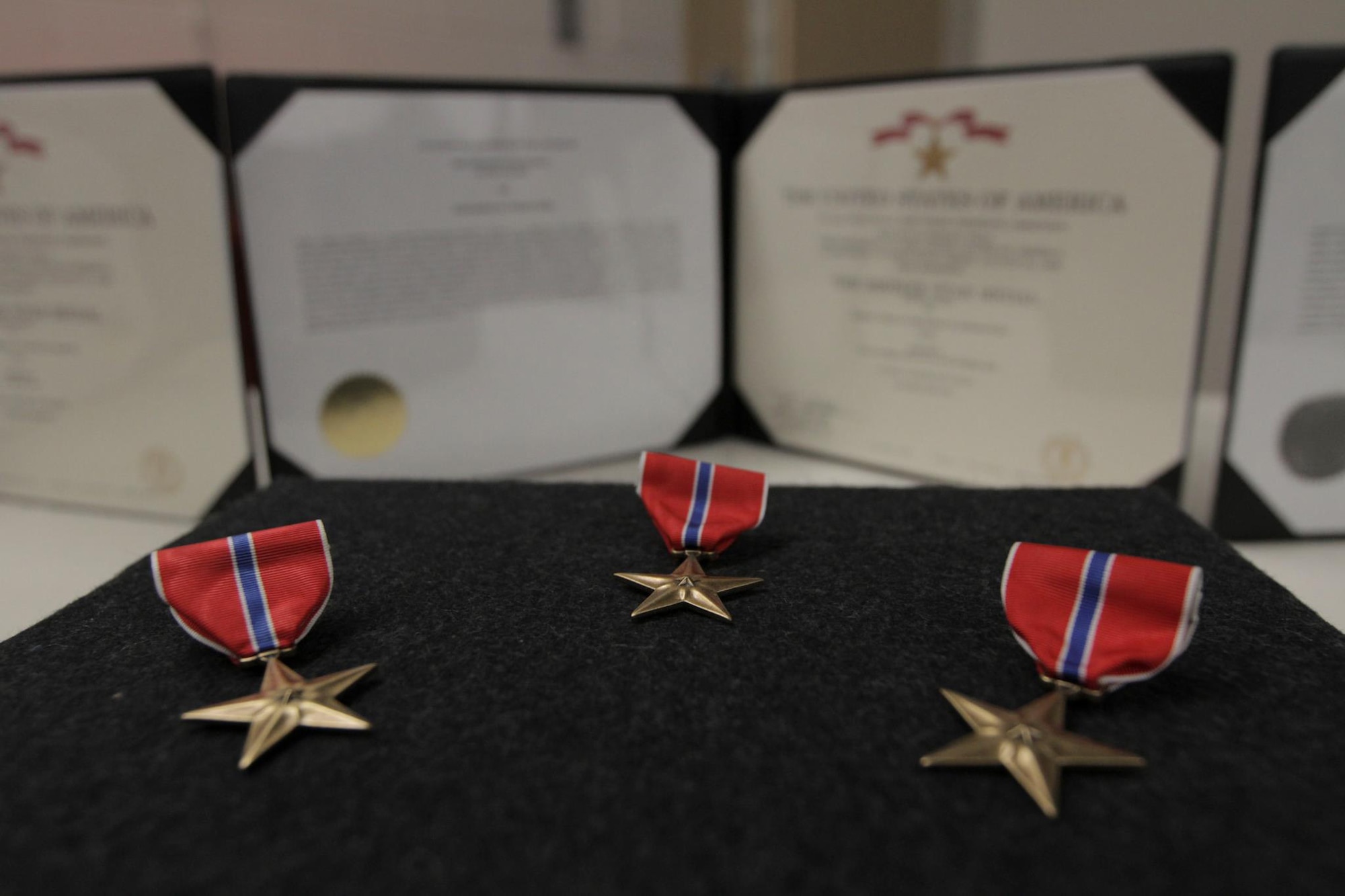 Three Bronze Star Medals lay waiting to be pinned on Tech. Sgt. Shane J. Hargis, Air Force Staff Sgt. Theodore M. Sierocinski and Capt. Koaalii C. Bailey stand during a Oct. 13 ceremony here. Guard photo by Air Force Maj. Guy Hayes.