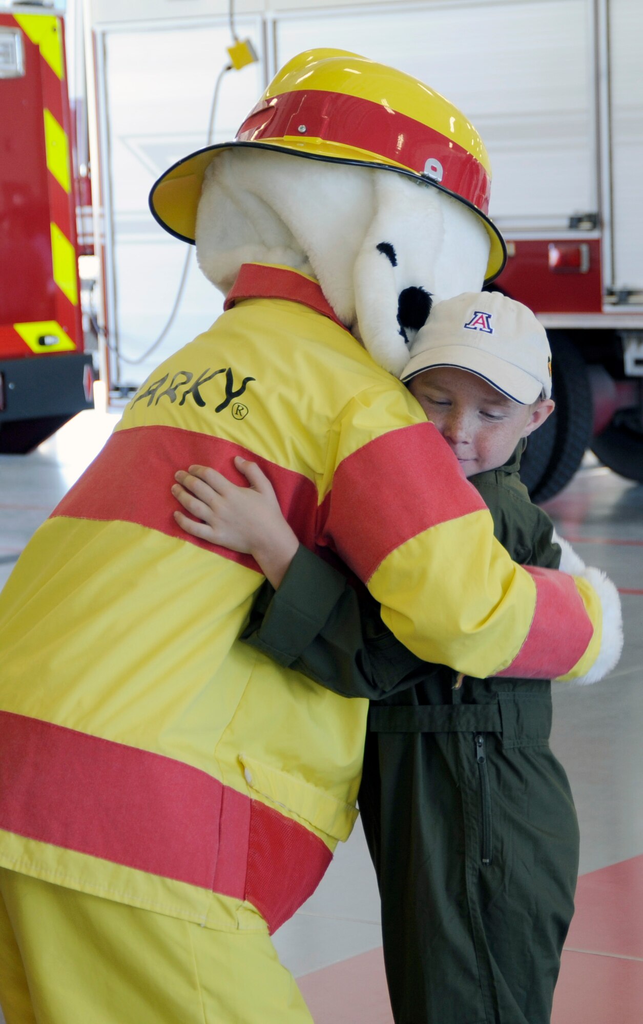 Eight-year-old Larry Ronstadt hugs Sparky the Dog after his tour of the base Fire Department as part of the Pilot for a Day program at Davis-Monthan Air Force Base, Ariz., Oct 25, 2012.  Larry was diagnosed with leukemia in December 2012. The program provides children with a terminal illness a day to visit the base and become an honorary pilot for one of the operational squadrons.  Sparky was played by U.S. Air Force Airman 1st Class James Mullenix, who is a firefighter with the base Fire Department. (U.S. Air Force photo by 1LT Susan Harrington/released)