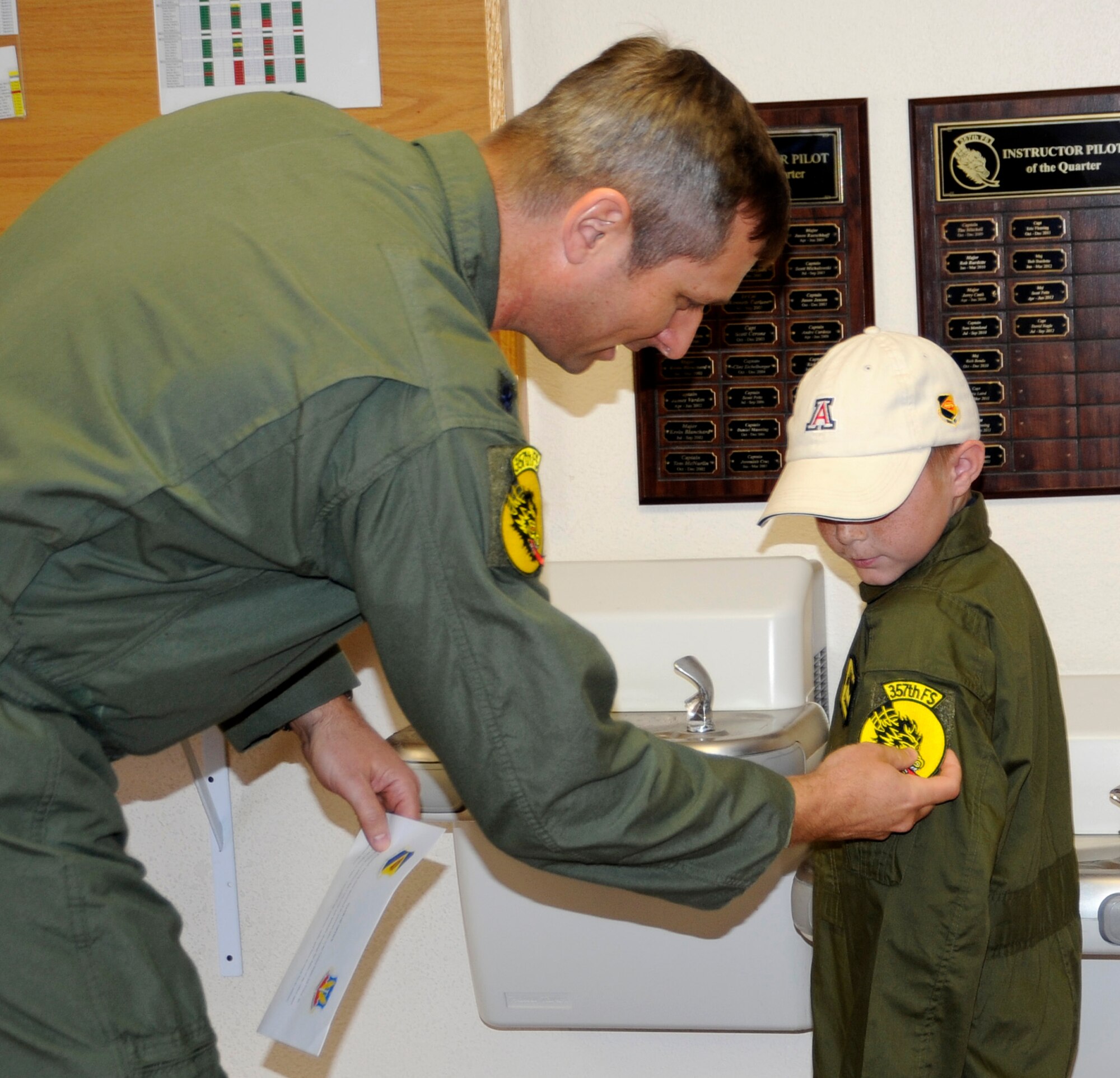 U.S. Air Force Lt Col. John Gabriel, 357th Fighter Squadron commander, gives Larry Ronstadt the 357th Fighter Squadron patch just after administering the Pilot for a Day "Oath of Office," during the Pilot for a Day program at Davis-Monthan Air Force Base, Ariz.  Larry was an honorary 357th FS pilot here on Oct 25, 2012, where he, his father and grandfather toured the squadron, visited an A-10 static, an HH-60 static and the base Fire Department.  Larry is the eight-year-old son of Jeff and Tiana Ronstadt. (U.S. Air Force photo by 1LT Susan Harrington/released)