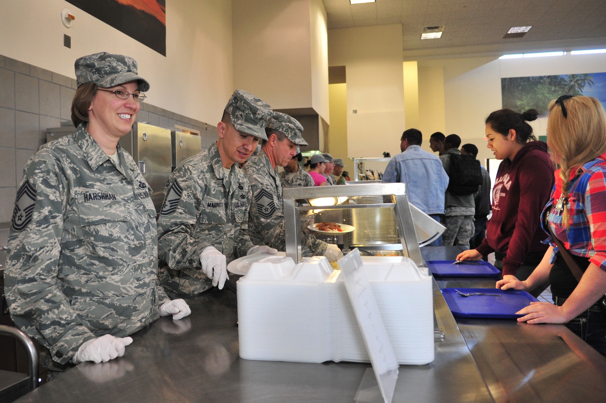 U.S. Air Force Chief Master Sgt. Lyn Harshman, 27th Special Operations Mission Support Group superintendent, Chief Master Sgt. Randolph Marriott, 27th Special Operations Communications Squadron superintendent, and Chief Master Sgt. Darren Dykes, 27th Special Operations Maintenance Operations Squadron superintendent, serve food to Air Commandos in the Pecos Trail Dining Facility at Cannon Air Force Base, N.M., Oct. 26, 2012. More than a handful of chief master sergeants put on their Airman Battle Uniform hats and food-handling gloves to happily serve fellow enlisted troops and foster a more casual rapport. (U.S. Air Force photo/Airman 1st Class Alexxis Pons Abascal)  