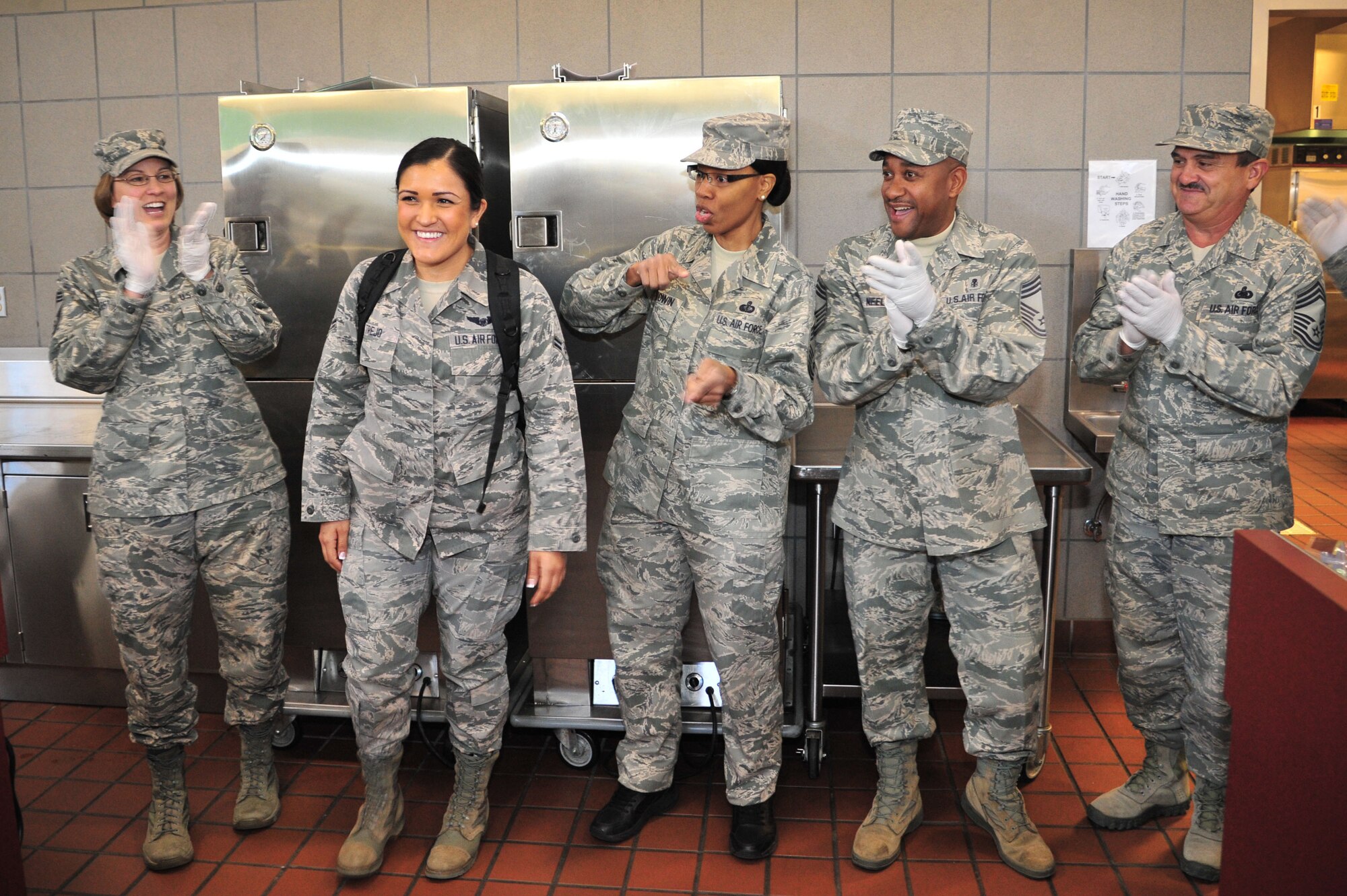 U.S. Air Force Chief Master Sgt. Lyn Harshman, 27th Special Operations Mission Support Group superintendent, sings happy birthday to Airman 1st Class Shanise Trejo, 551st Special Operations Squadron sensor operator, with the help of Chief Master Sgt. Tracy Goodwin, 27th Special Operations Force Support Squadron superintendent, Chief Master Sgt. Marvin Neely, 27th Special Operations Medical Group superintendent, and  Chief Master Sgt. Edward Kirk, 27th Special Operations Logistics Readiness Squadron superintendent, in the Pecos Trail Dining Facility at Cannon Air Force Base, N.M., Oct. 26, 2012. More than a handful of chief master sergeants put on their Airman Battle Uniform hats and food-handling gloves to happily serve fellow enlisted troops and foster a more casual rapport. (U.S. Air Force photo/Airman 1st Class Alexxis Pons Abascal)  