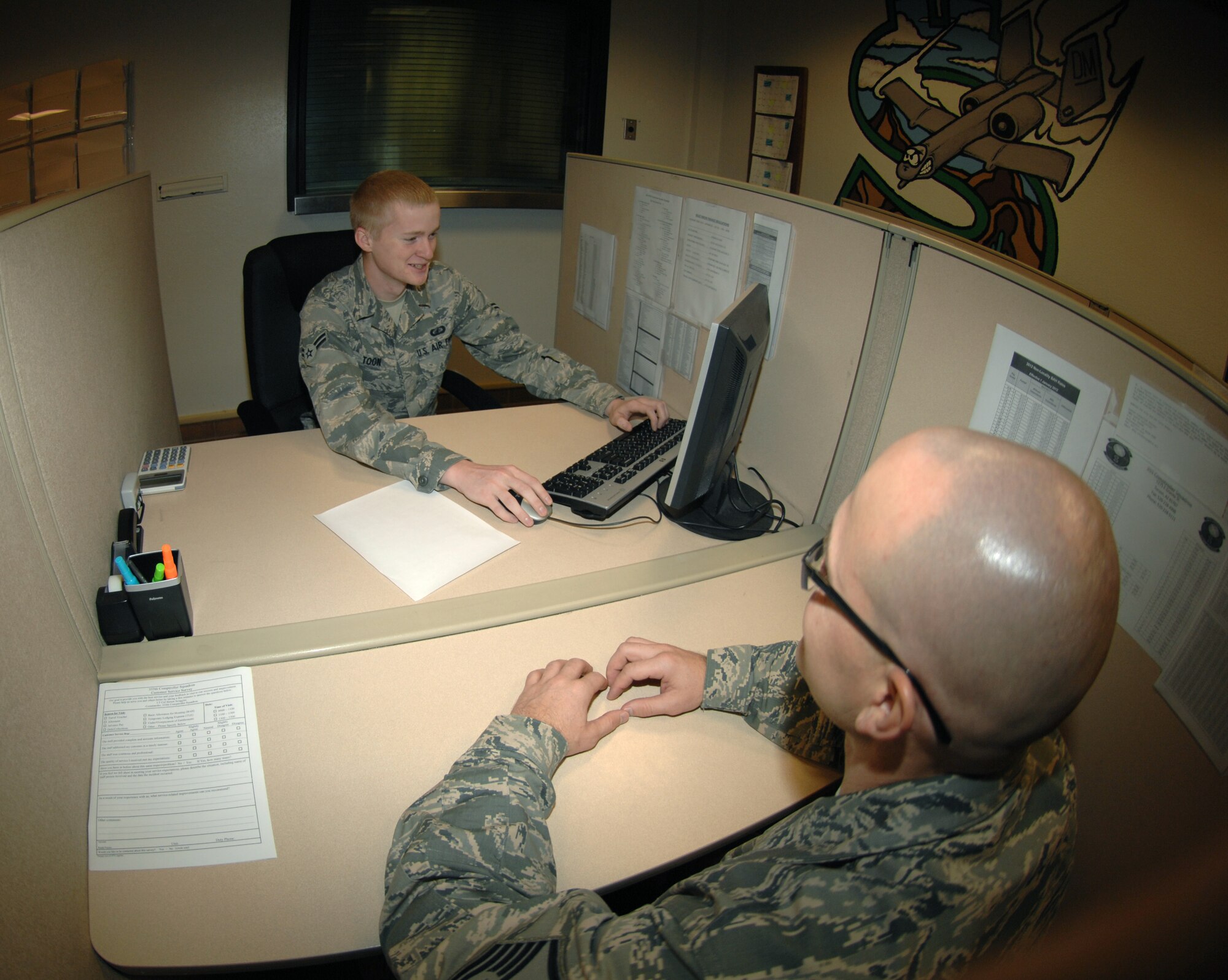 U.S. Air Force Airman 1st Class Zachary Toon, 355th Comptroller Squadron customer service technician, helps out a customer at Davis-Monthan Air Force Base, Ariz. Oct. 25. The Airmen at the customer service area deal with about 1,250 individuals per month. (U.S. Air Force photo by Senior Airman Michael Washburn/Released)
