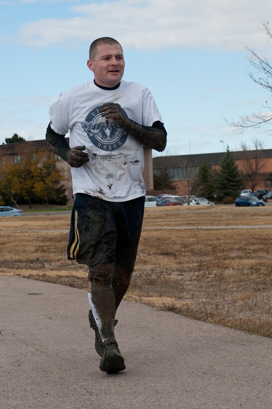 Tech. Sgt. Kevin Rotondelli, 28th Maintenance Operations Squadron technical order manager, jogs to the finish line of the 2012 Mud Run at Ellsworth Air Force Base, S.D., Oct. 23, 2012. The event was a 1.5-mile course consisting of several mental and physical obstacles designed to promote National Energy Action Month awareness. (U.S. Air Force photo by Airman 1st Class Kate Thornton-Maurer/Released)