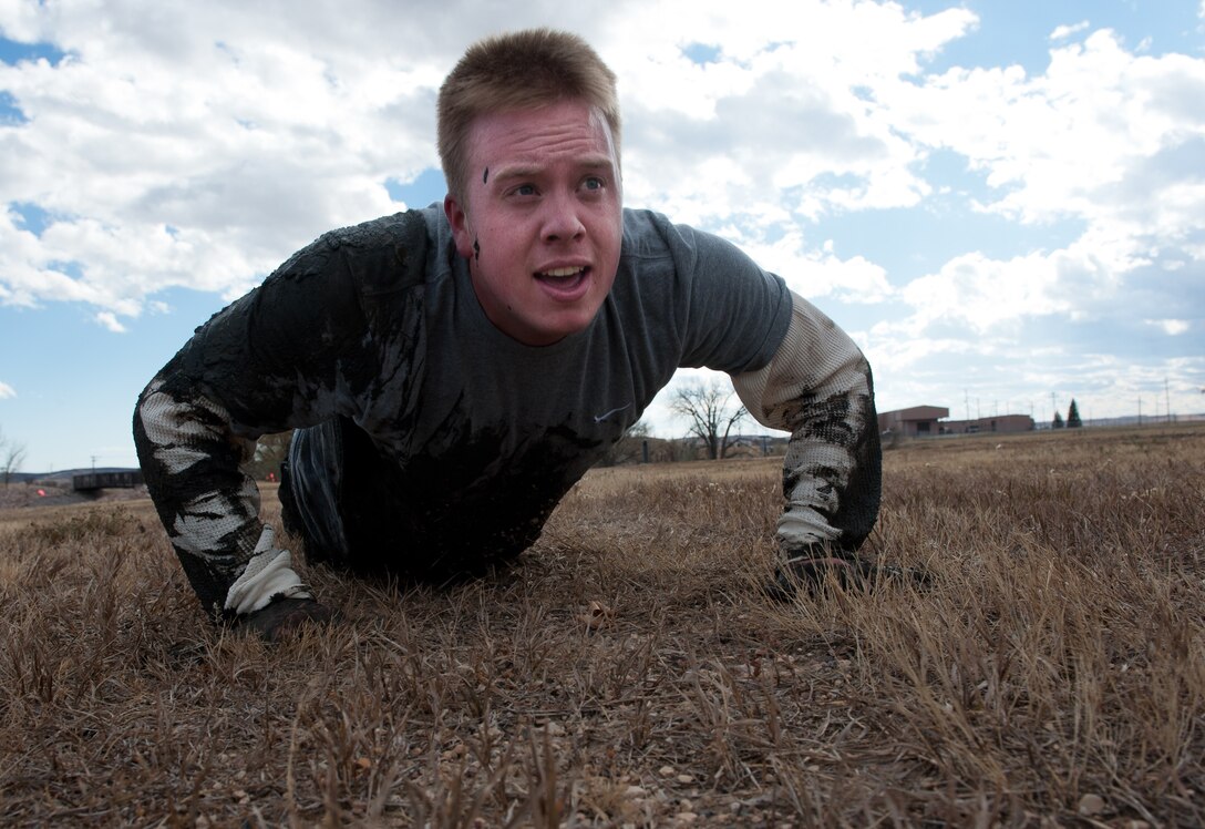 Senior Airman Benjamin Rongey, 28th Civil Engineer Squadron electrical systems technician, performs a burpee exercise during the 2012 Mud Run at Ellsworth Air Force Base, S.D., Oct. 23, 2012. Several obstacles on the course tested the ability to memorize information and then answer questions correctly at a later time. If participants answered incorrectly, they were required to complete 30 burpees. (U.S. Air Force photo by Airman 1st Class Kate Thornton-Maurer/Released)