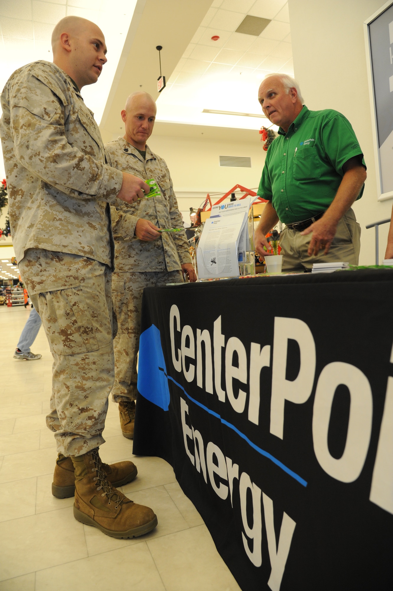 Marine Staff Sgt. Chad Radich and Marine Sgt. Anthony Cornwall, Keesler Marine Detachment, receive pamphlets and mementos from Charles Campbell, Center Point Energy, at the Exchange to promote Energy Action Month Oct. 24, 2012, Keesler Air Force Base, Miss. Energy Action Month provides an opportunity to promote energy and water conservation awareness to Airmen as part of a national campaign led by the Department of Energy.  (U.S. Air Force photo by Kemberly Groue)