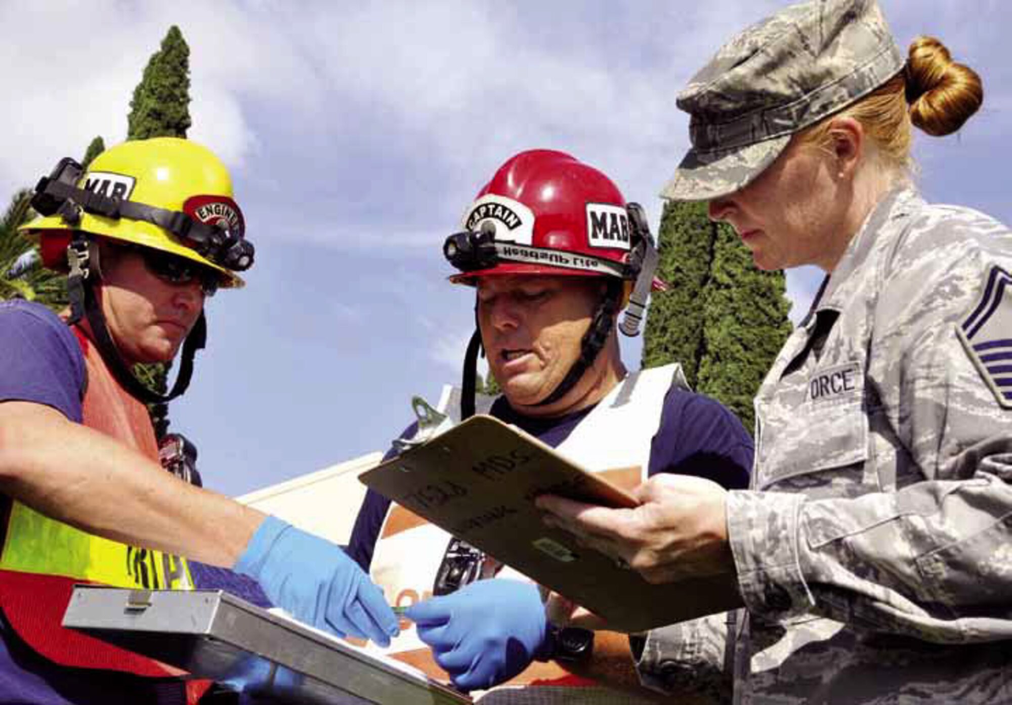 Paul Hoffman, left, and Chris Christianson, March firefighters, provide updates to Senior Master Sgt. Briarly Saavedra, 452nd Aeromedical Staging Squadron, on March personnel during The Great Shake Out earthquake exercise Oct. 18, 2012. Team March participates in the annual event. According to the U.S. Geological Survey, March is located in the Southern California (East) Earthquake Hazard Area, which is highly susceptible to shaking during an earthquake. Nearly 1.5 million SCEHA residents participated in the drill this year. (U.S. Air Force photo by Linda Welz)