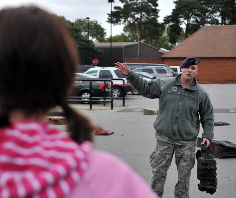 Staff Sgt. Samuel Giordano, 100th Security Forces Squadron military working dog handler, speaks prior to a military working dog demonstration Oct. 26, 2012, during the Security Awareness Month Expo 2012 at the Base Exchange parking lot on RAF Mildenhall, England. Sponsored by the Installation Security Advisory Group, the month-long campaign aimed to highlight the importance of security at work and at home. (U.S. Air Force photo by Senior Airman Jerilyn Quintanilla/Released)