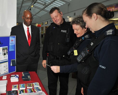 Richard Blackledge, 100th Air Refueling Wing Anti-terrorism officer, speaks to, from left, Police Constable Paul Borman, Police Community Support Officers Sharon Caws and PCSO Jane Edwards Oct. 26, 2012, during the Security Awareness Month Expo 2012 at the Base Exchange at RAF Mildenhall, England. Sponsored by the Installation Security Advisory Group, the month-long campaign aimed to highlight the importance of security at work and at home. (U.S. Air Force photo by Senior Airman Jerilyn Quintanilla/Released)