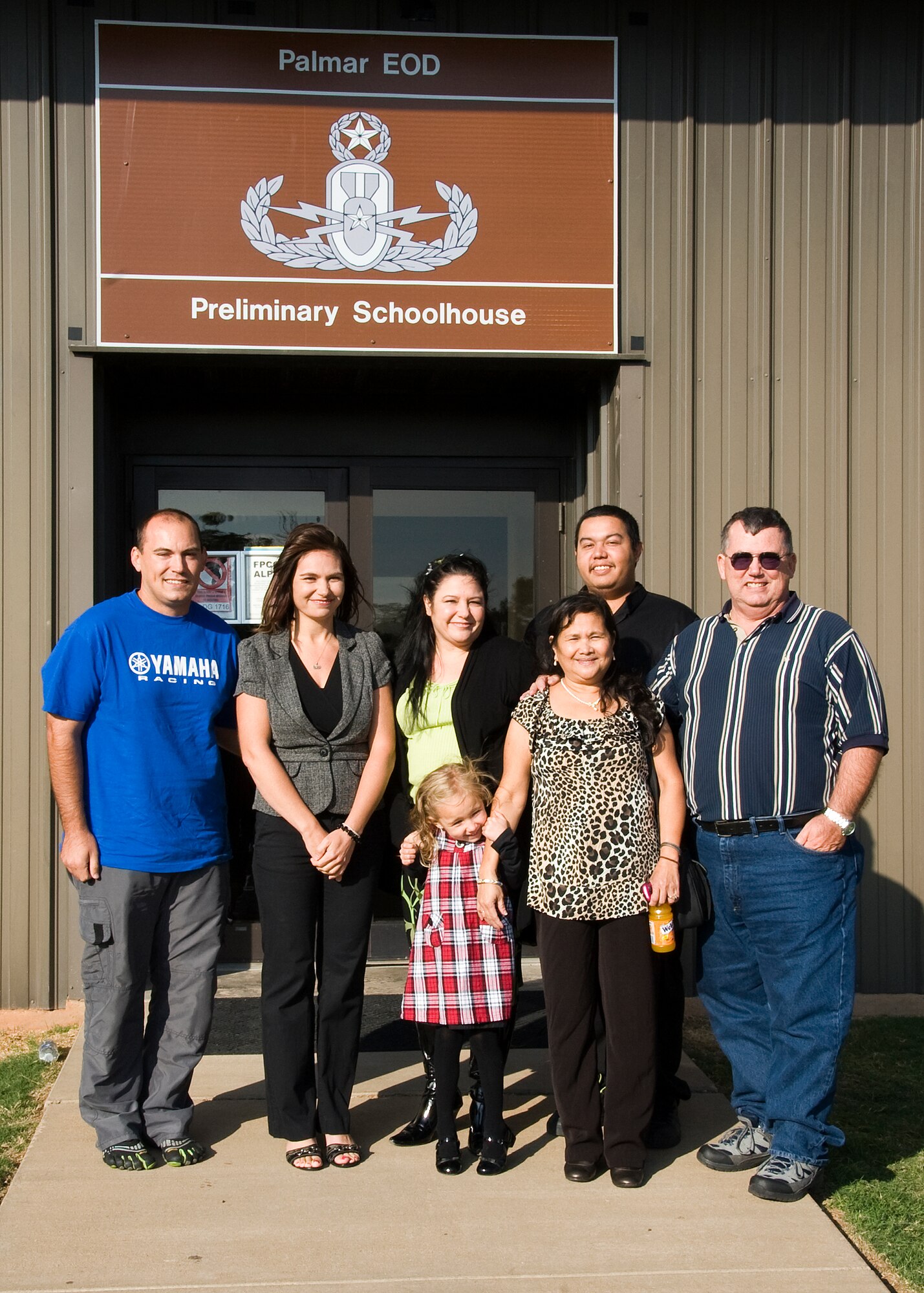 LaDeane Palmar (2nd from left) and daughter Makayla (front center), with family members during the dedication ceremony after the unveiling of the "Palmar EOD Preliminary Schoolhouse" sign on bldg 1719 on Sheppard training annex Oct. 26, 2012.  The schoolhouse was renamed in memory of Tech. Sgt. Rick Palmar, an EOD instructor who passed away in December, 2009. (U.S. Air Force photo/Frank Carter)