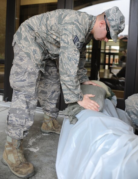 U.S. Air Force Staff Sgt. Daniel Schrader, 633rd Civil Engineer Squadron water and fuel systems maintenance craftsman, moves sandbags to various buildings to prevent flooding in preparation for Hurricane Sandy, Langley Air Force Base, Va., Oct. 26, 2012. Due to a partnership with NASA, the 633rd CES uses the Flood Impact Analysis Tool to determine locations that need more flood protection through the use of sand bags, keeping water out of buildings. (U.S. Air Force photo by Airman 1st Class Teresa Aber)