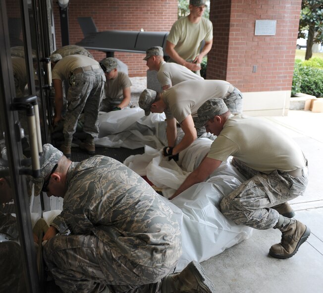 U.S. Airmen from the 633rd Civil Engineer Squadron move sandbags to various buildings to prevent flooding in preparation for Hurricane Sandy, Langley Air Force Base, Va., Oct. 26, 2012. Due to a partnership with NASA, the 633rd CES uses the Flood Impact Analysis Tool to determine locations that need more flood protection through the use of sand bags, keeping water out of buildings. (U.S. Air Force photo by Airman 1st Class Teresa Aber)