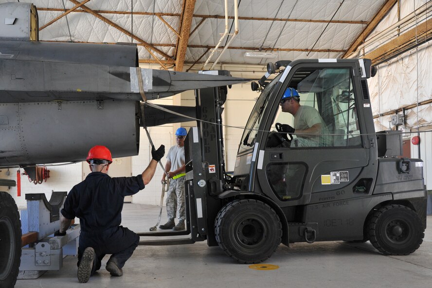 The cradle is positioned to receive the F-16 fuselage being crated and packed for shipment to Hill AFB. The aircraft must be supported in specific locations to eliminate unnecessary stress and damage to the airframe.  This specific depot team consists of 56 individuals from five career fields. (U.S. Air Force photo by Senior Airman Sandra Welch)